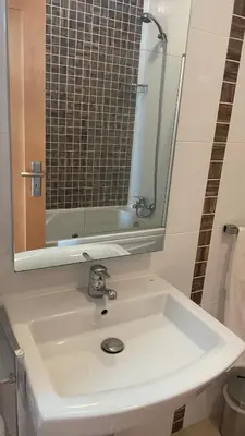 a bathroom with a white sink and a mirror at Amazing 2 Bedroom Apartment near beach with pool in Lagos