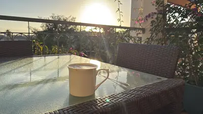 a coffee cup sitting on a glass table on a patio at Amazing 2 Bedroom Apartment near beach with pool in Lagos