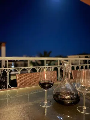 two glasses of wine and a vase on a table at Amazing 2 Bedroom Apartment near beach with pool in Lagos