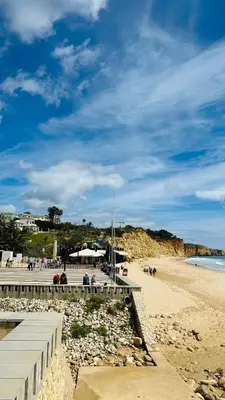 a beach with a pier and people on the beach at Amazing 2 Bedroom Apartment near beach with pool in Lagos