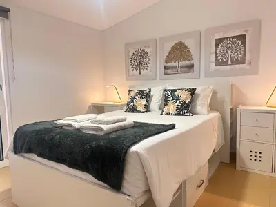 a white bedroom with a bed with pillows on it at Golden Beach House in Porto Santo