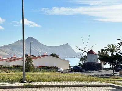 a street with a windmill and a building and a house at Golden Beach House in Porto Santo