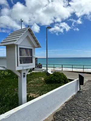 a book stand on a sidewalk near the beach at Golden Beach House in Porto Santo