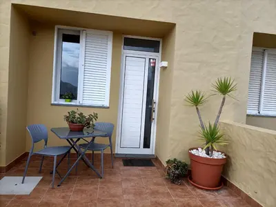 a patio with a table and chairs and plants at Golden Beach House in Porto Santo