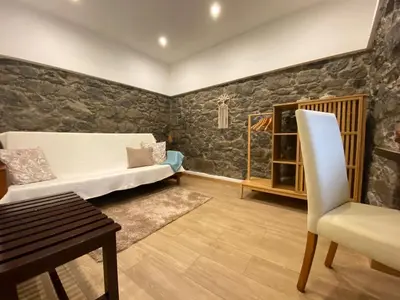 a living room with a couch and a chair at Penha D'Águia Villa in Porto da Cruz