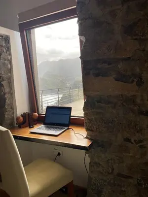 a laptop computer sitting on a desk next to a window at Penha D'Águia Villa in Porto da Cruz