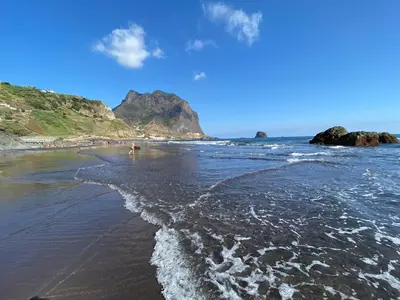 a beach with rocks and the ocean with waves at Penha D'Águia Villa in Porto da Cruz
