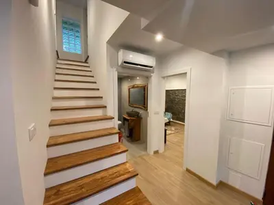 a staircase in a home with white walls and wooden floors at Penha D'Águia Villa in Porto da Cruz
