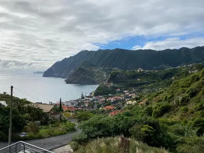 a town on a hill next to the ocean at Penha D'Águia Villa in Porto da Cruz