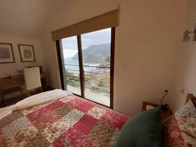 a bedroom with a bed and a large window at Penha D'Águia Villa in Porto da Cruz