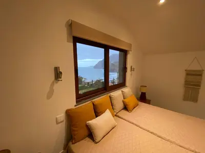 a bedroom with a bed with a large window at Penha D'Águia Villa in Porto da Cruz