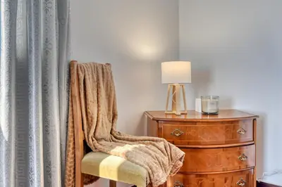a room with a chair next to a dresser and a lamp at Casa do Valentim, a Home in Madeira in Ponta do Sol
