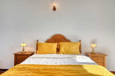 a bedroom with a bed with yellow sheets and two night stands at Casa do Valentim, a Home in Madeira in Ponta do Sol