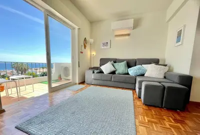 a living room with a couch and a large window at Avenue Q, Beach Apartment in Luz in Luz
