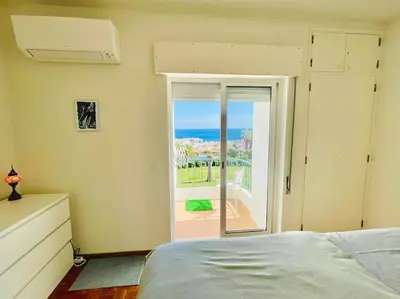 a bedroom with a bed and a view of the ocean at Avenue Q, Beach Apartment in Luz in Luz