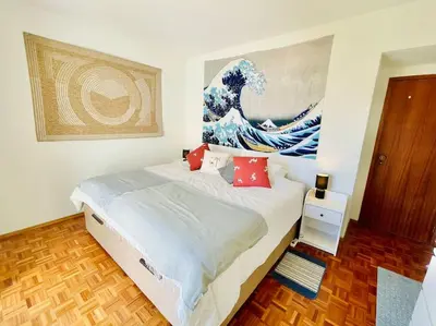 a bedroom with a bed with a painting on the wall at Avenue Q, Beach Apartment in Luz in Luz