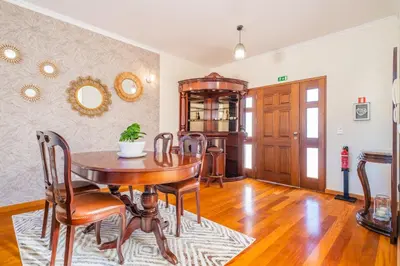 a dining room with a wooden table and chairs at Gaula Residence by Homie in Santa Cruz