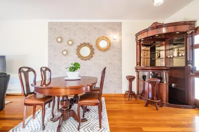 a dining room with a wooden table and chairs at Gaula Residence by Homie in Santa Cruz