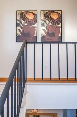 a staircase with three pictures of a woman on the wall at Gaula Residence by Homie in Santa Cruz