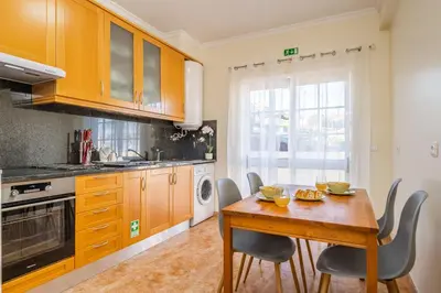a kitchen with a wooden table and chairs at Gaula Residence by Homie in Santa Cruz