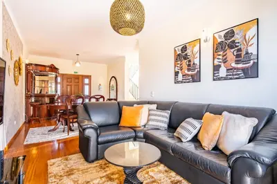 a living room with a leather couch and a table at Gaula Residence by Homie in Santa Cruz