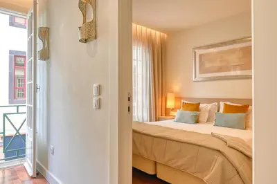 a bedroom with a bed and a window at Colombo Square, a Home in Madeira in Funchal