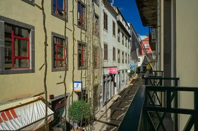 a narrow alley with buildings in a city at Colombo Square, a Home in Madeira in Funchal