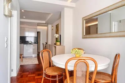 a dining room with a table and chairs and a mirror at Colombo Square, a Home in Madeira in Funchal