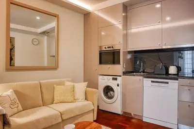 a living room with a couch and a kitchen at Colombo Square, a Home in Madeira in Funchal