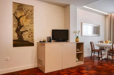 a living room with a tv on a cabinet at Colombo Square, a Home in Madeira in Funchal