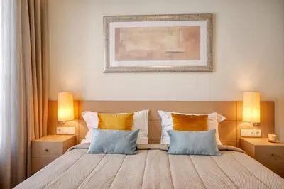 a bedroom with a bed with yellow pillows at Colombo Square, a Home in Madeira in Funchal