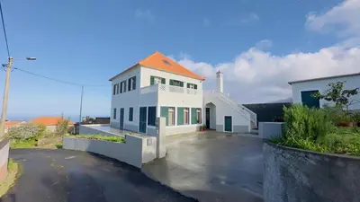 a large white house with an orange roof at CASA CAROTO in Porto Moniz