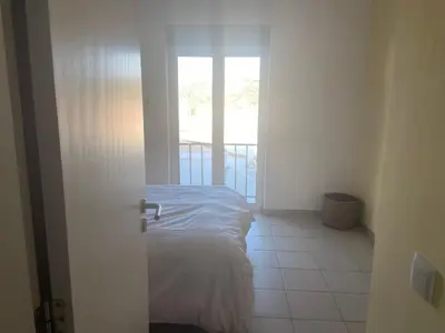 a bedroom with a bed and a door to a balcony at Casa Sea Love Luz in Luz