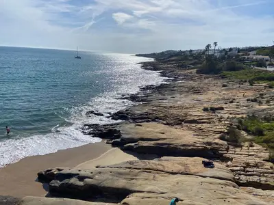 a rocky beach with a boat in the water at Casa Sea Love Luz in Luz