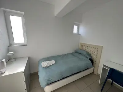 a small bedroom with a bed and a desk at Casa Sea Love Luz in Luz