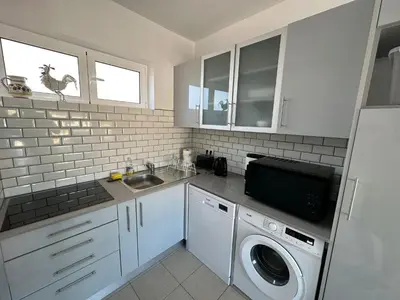a kitchen with a sink and a washing machine at Casa Sea Love Luz in Luz