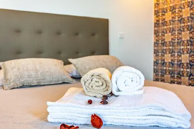 a pile of towels and rolled towels on a bed at Panoramic Views I I in Caniço