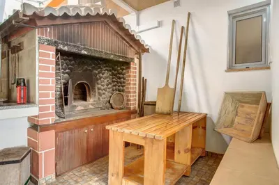 a brick oven with a wooden table in a room at Panoramic Views I in Caniço