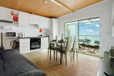a kitchen and dining room with a table and chairs at Panoramic Views I in Caniço