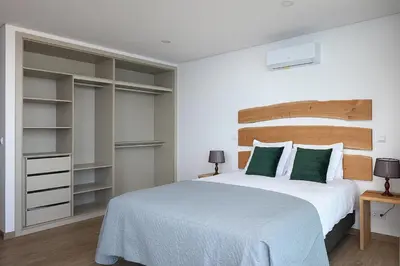 a bedroom with a large white bed with green pillows at Peak A Boo Private Heated Pool and Private Parking in Câmara de Lobos