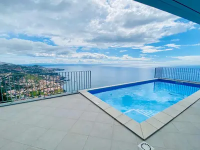 a swimming pool on a balcony with a view of the water at Peak A Boo Private Heated Pool and Private Parking in Câmara de Lobos