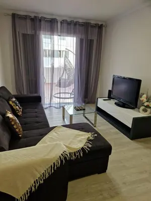 a living room with a couch and a flat screen tv at Lovely Apartment Funchal in Funchal