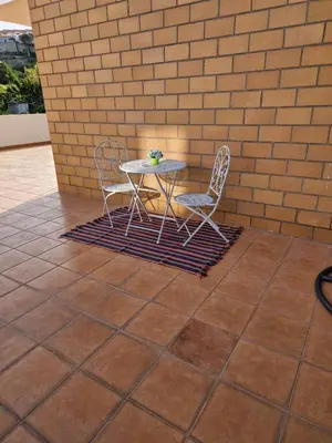 a table and two chairs and a table and a brick wall at Lovely Apartment Funchal in Funchal
