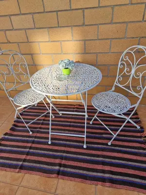 a table with two chairs and a table with a vase at Lovely Apartment Funchal in Funchal