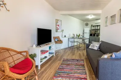 a living room with a couch and a tv at Palmeira House - Fernandes Cottage in Ponta Delgada