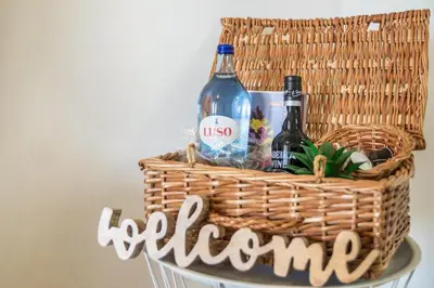 a basket with wine bottles and a sign that says welcome at Palmeira House - Fernandes Cottage in Ponta Delgada