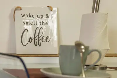 a coffee sign and a cup on a table at Palmeira House - Fernandes Cottage in Ponta Delgada