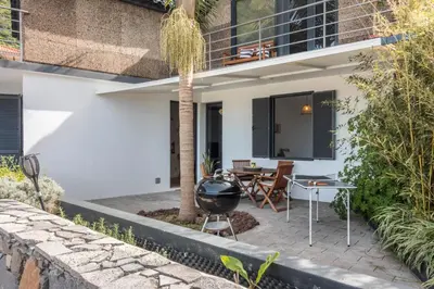 a patio with a bbq grill next to a house at Palmeira House - Fernandes Cottage in Ponta Delgada
