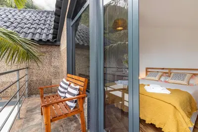 a room with a balcony with a chair and a table at Cork House - Fernandes Cottage in Ponta Delgada