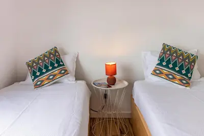 two beds in a room with a candle on a table at Cork House - Fernandes Cottage in Ponta Delgada
